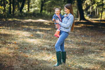 Fototapeta premium Young mother with her little daughter in an autumn park