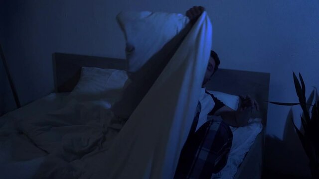 slow motion of man in pajamas going to bed at night
