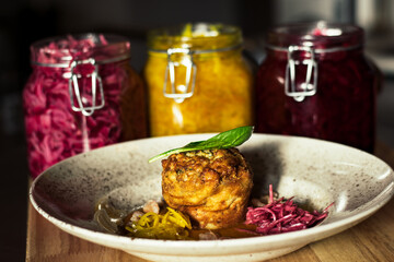 Pike cutlet with pumpkin sauce and fermented cabbage in different colors at a restaurant