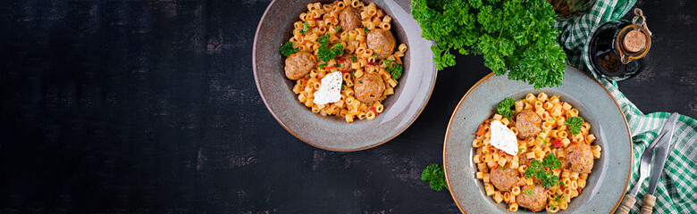 Italian traditional ditalini pasta with meatballs in tomato sauce and vegetables in bowl.  Ditalini pasta and beef balls  with marinara tomato sauce. Top view. Flat lay.