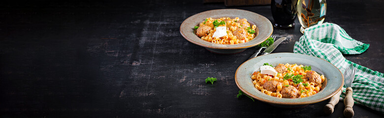 Italian traditional ditalini pasta with meatballs in tomato sauce and vegetables in bowl.  Ditalini pasta and beef balls  with marinara tomato sauce.