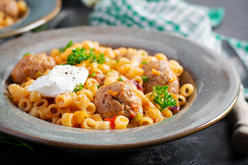 Italian traditional ditalini pasta with meatballs in tomato sauce and vegetables in bowl.  Ditalini pasta and beef balls  with marinara tomato sauce.
