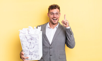 young handsome man feeling like a happy and excited genius after realizing an idea paper balls...