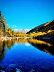 beautiful blue mountain lake, travel through the autumn mountains, autumn colors, mountains and trees are reflected in the water, Russia Karachay-Cherkessia Dombay