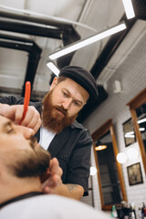 Professional barber, clipper cutting, shaving beard of regular customer at barbershop. Beauty, selfcare, style, fashion and male cosmetics concept.