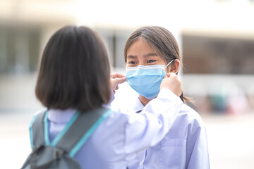 Children students in student uniform wearing protective face mask for each other to go to school after COVID-19 pandemic situation getting better. Back to School Concept Stock Photo