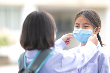 Children students in student uniform wearing protective face mask for each other to go to school after COVID-19 pandemic situation getting better. Back to School Concept Stock Photo