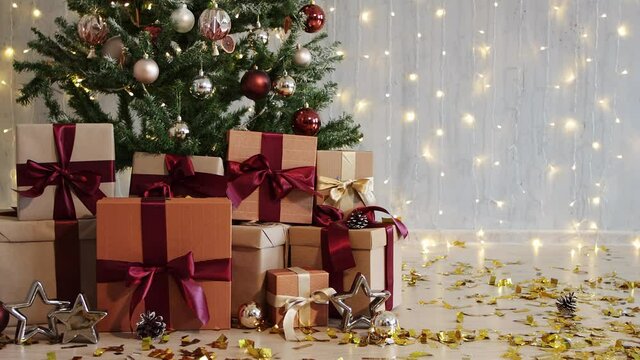 winter holidays background - heap of christmas gifts under christmas tree, copy space with led lights 