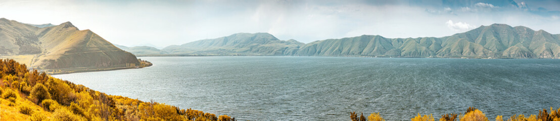 Panoramic view of famous Sevan lake with bald mountain ranges. Dramatic and harsh northern...