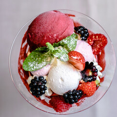 Ice cream serving in a glassware with different berries
