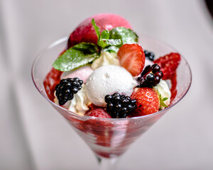 Ice cream serving in a glassware with different berries