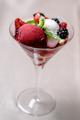 Ice cream serving in a glassware with different berries