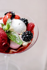 Ice cream serving in a glassware with different berries