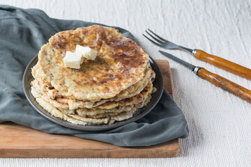 Stack of homemade whole wheat flour tortillas on a linen tablecloth, selective focus