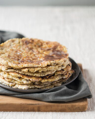 Stack of homemade whole wheat flour tortillas on a linen tablecloth, selective focus