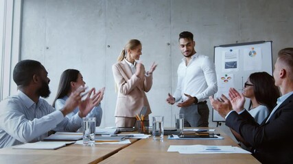 Promotion at work. Positive lady boss introducing new arab man colleague to diverse business group, zoom in