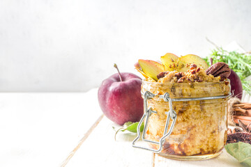 Autumn apple pecan oatmeal, overnight oats porridge with red apples, pecan nuts and caramel sauce,...