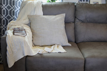 Neutral throw pillow over a grey couch in a farmhouse style living room with knit blanket, closed...