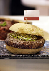 hamburguesa de ternera con brotes de soja y bollo de pan con cartelito