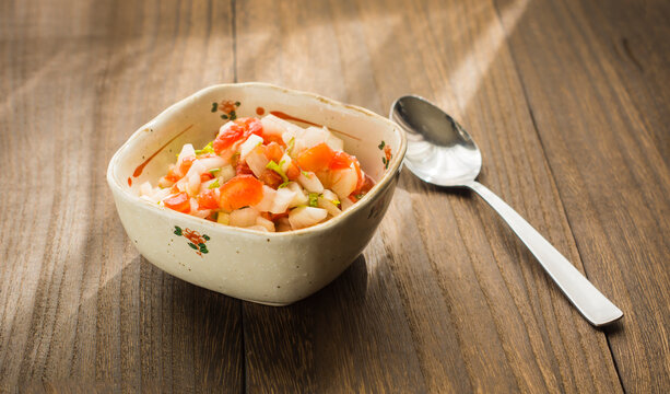 brazilian cuisine. A plate with vinagrete  and spoon on a wooden base.  