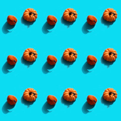 Autumn halloween holiday concept. Pattern from pumpkins. Flat lay on blue background.