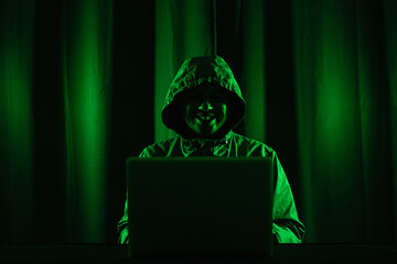 Hackers wear hoods to cover their faces. Hacking to steal important information. Use a computer to...