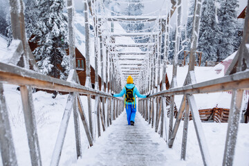woman walking by icy snowed stairs at winter mountains resort