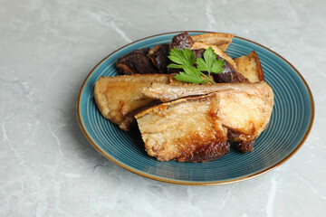 Tasty fried pork lard with parsley on light table