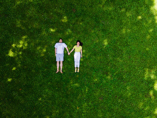 smiling couple laying down on green grass