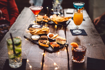 Blurred background of multicolored drinks and minimal food - Happy hour concept with fancy...