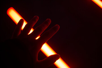 Mano sobre luces fluorescentes rojas