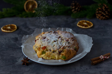 Christmas Stollen against the background of spruce branches and gray concrete