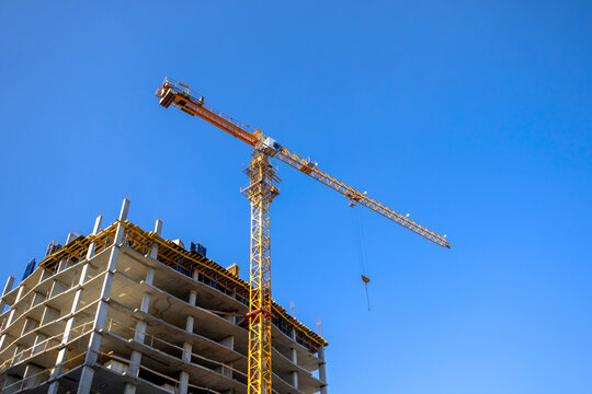 Construction crane on construction site, blue sky background, urban industry concept photo