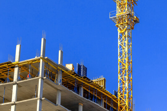 Construction site and contruction tower crane on a clear blue sky background photo