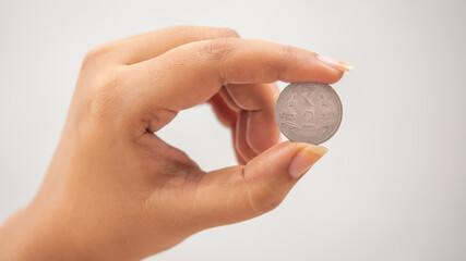 Indian currency in two-rupee coin hand 