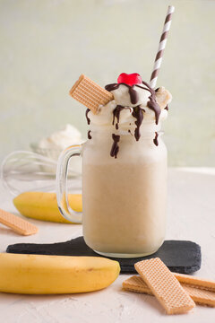 Yummy banana split milkshake with waffle and straw