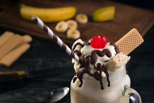 Yummy banana split milkshake with waffle and straw