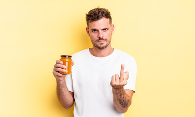 young handsome man feeling angry, annoyed, rebellious and aggressive. peach jelly concept