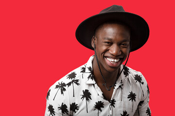 Happy black man in trendy outfit in studio