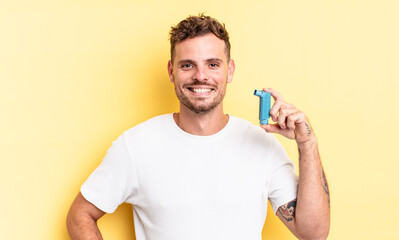 young handsome man smiling happily with a hand on hip and confident. asthma concept