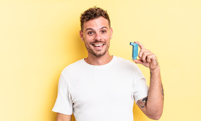young handsome man looking happy and pleasantly surprised. asthma concept