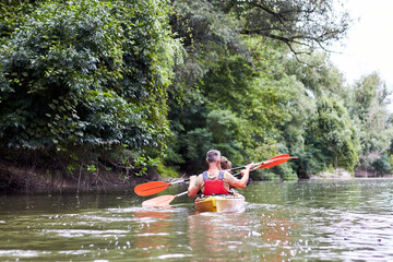 Couple kayaking together in the river. Having fun in leisure activity. Woman and man on the kayak. Sport, relations concept. Back view