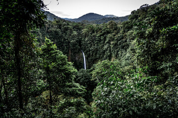 Beautiful view of the Rio Fortuna Waterfall flowing down the green mountains
