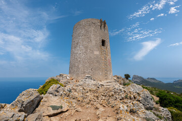Fototapeta na wymiar The remains of the centuries-old Albercutx watchtower on the Spanish Mediterranean island of Mallorca. In the background you can see the eastern part of the Formentor peninsula and the sea.