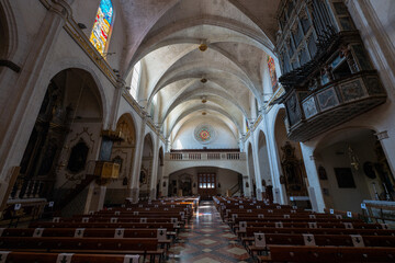 Fototapeta premium The interior of the old historic church of Felanitx on the Spanish Mediterranean island of Mallorca. At the back is the entrance and to the right and left are benches. At the top right is the organ.
