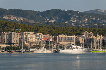Naklejka premium Early morning view of the city of Palma de Mallorca. Large yachts are on the quay. In the background is the city and the mountains of the Mediterranean island.
