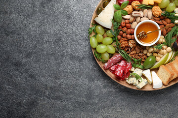 Different tasty appetizers on dark grey table, top view. Space for text