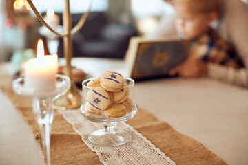 Jewish cookies in jar with mother and son in background.
