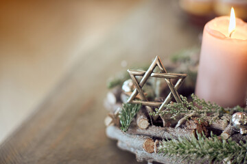 Close-up of star of David and candlelight on table during Hanukkah celebration.