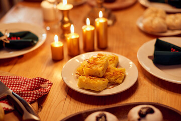 Jewish noodle casserole with candlelight on dining table on Hanukkah.